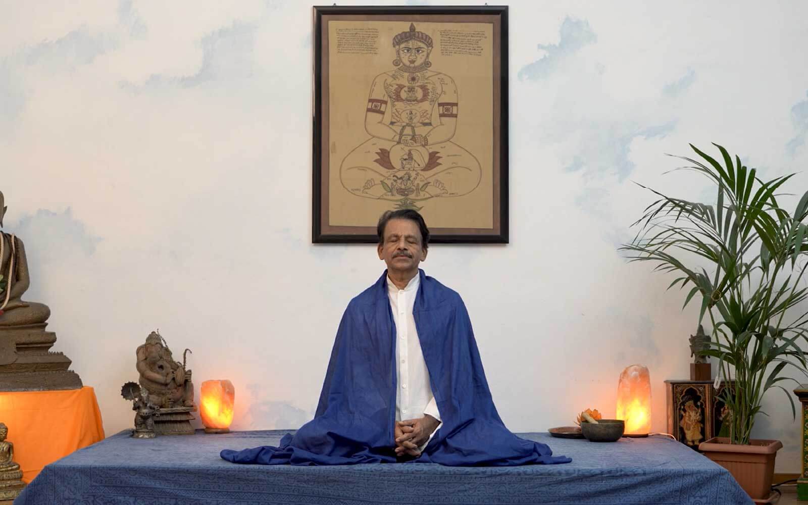 II maestro James Eruppakkattu siede in meditazione nella posizione del loto
