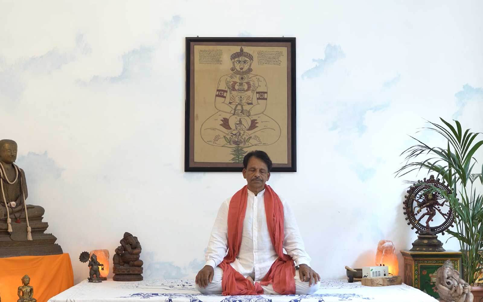 Il maestro James Eruppakkattu siede nella posizione del loto durante la pratica di Pranayama