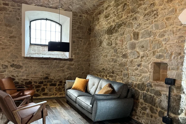 Salotto in pietra di un ritiro yoga immerso nella natura a Canossa